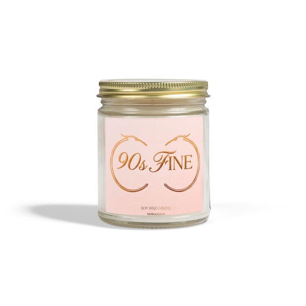 90's Fine affirmation candle in a clear glass jar with a gold lid and pink label featuring gold hoop earrings.