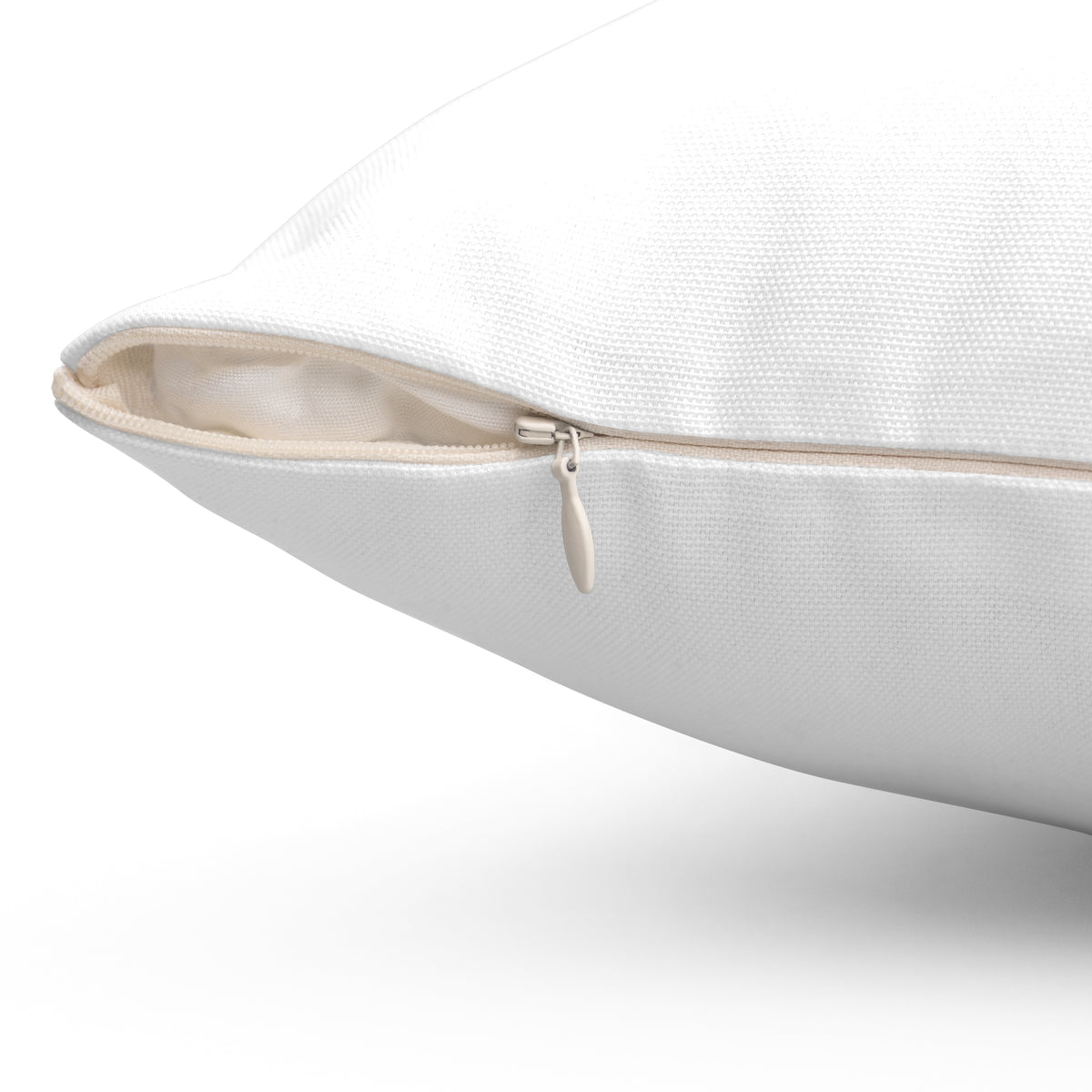 Close-up of a white polyester throw pillow with a concealed beige zipper.
