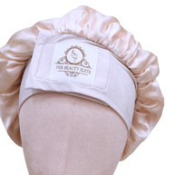 blush light pink pink double-layered mulberry silk bonnet with an adjustable, non-slip stretchy band and branded logo patch.