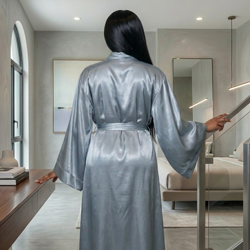 Woman from behind wearing a full-length, silky gray satin kimono robe with wide sleeves and a waist tie.