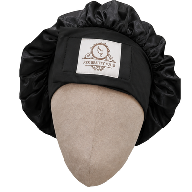 Black double-layered mulberry silk bonnet with an adjustable non-slip band and Her Beauty Suite logo on a mannequin head.