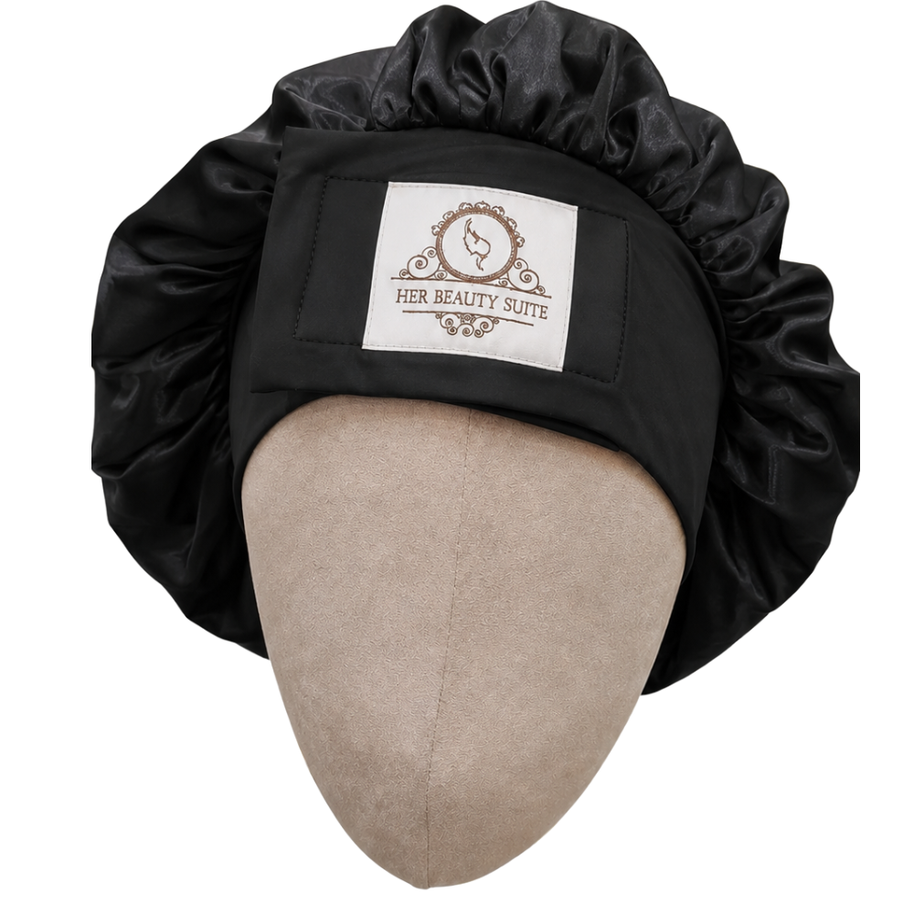 Black double-layered mulberry silk bonnet with an adjustable non-slip band and Her Beauty Suite logo on a mannequin head.