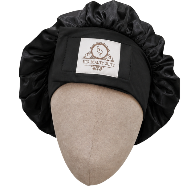 Black double-layered mulberry silk bonnet with an adjustable non-slip band and Her Beauty Suite logo on a mannequin head.